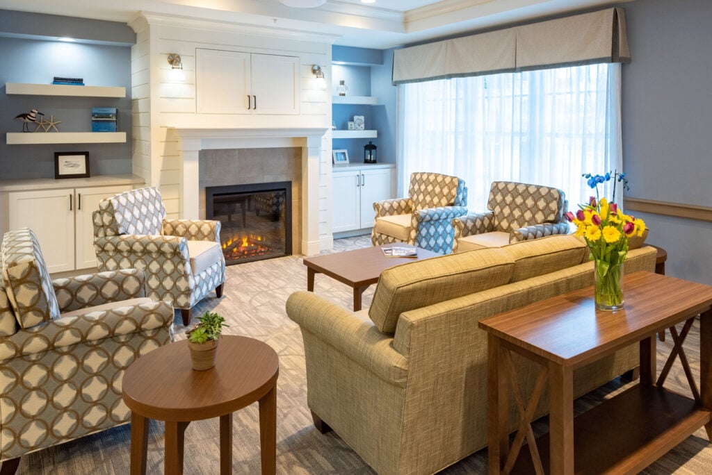 Lounge of chairs and a couch facing a lit fireplace.